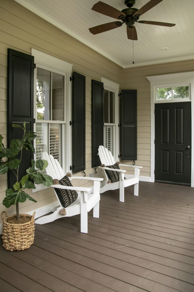 Charleston style porch with chairs and entry door on southern home